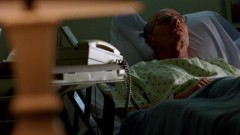 Walt lies in his hospital bed.