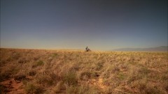 A kid drives through the desert.