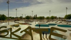 Saul talks to the two skaters at a skate park.