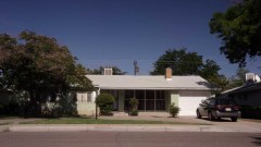 Mike sits in his car outside a house.