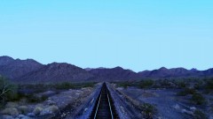 A train drives through the desert.